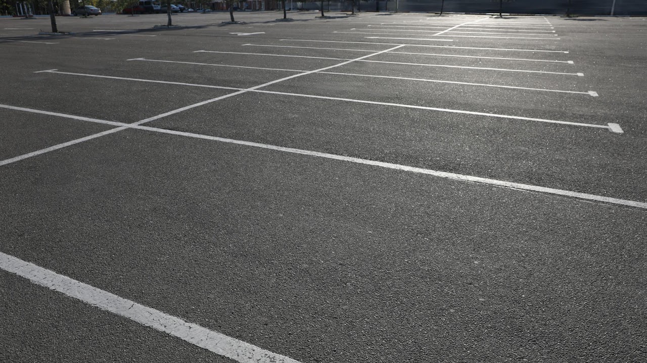 A freshly paved parking lot with neatly marked white lines for parking spaces for recent commercial project for client in Morris County, NJ, showcasing the professional paving and maintenance services offered by Morris Town Paving.