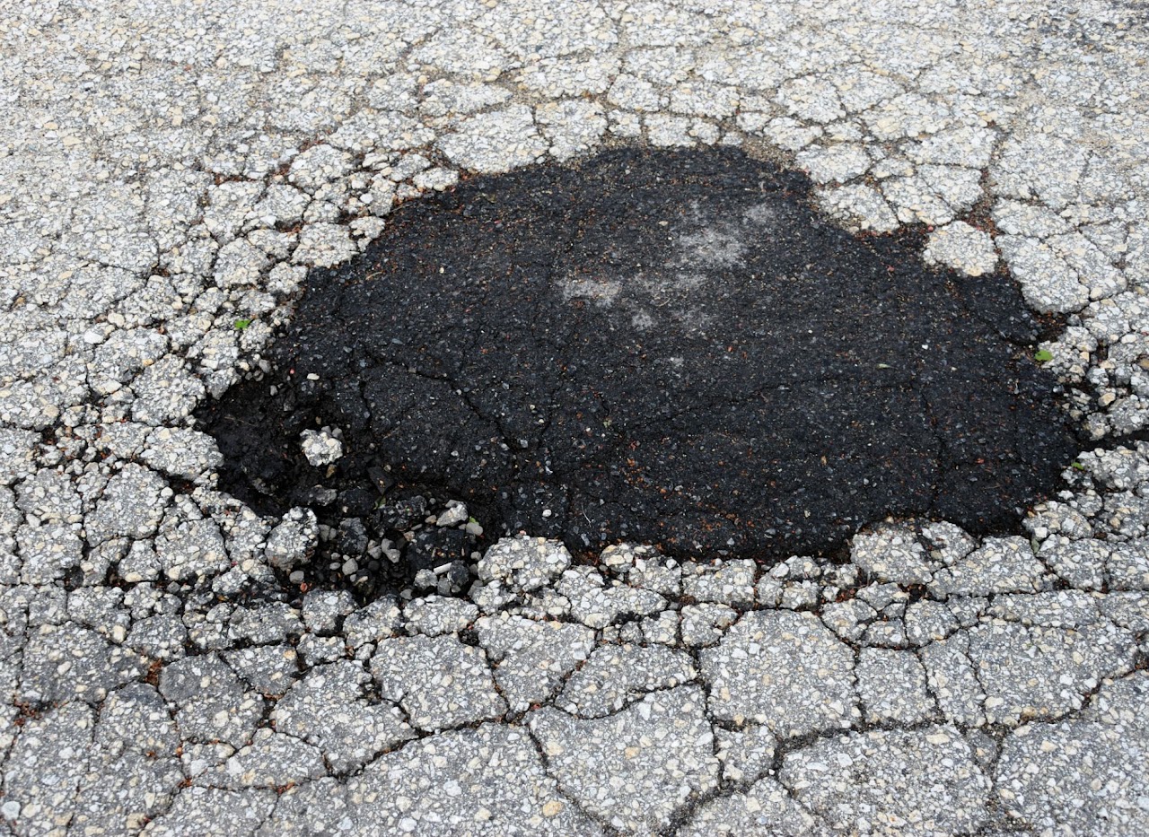 A recent asphalt filling of a pothole in Morris County, NJ, highlighting Morris Town Paving’s asphalt patch repair and pothole filling services.